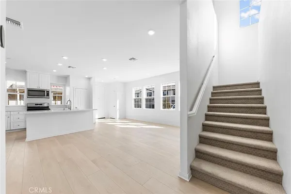 a view of an entryway with wooden floor and a kitchen view
