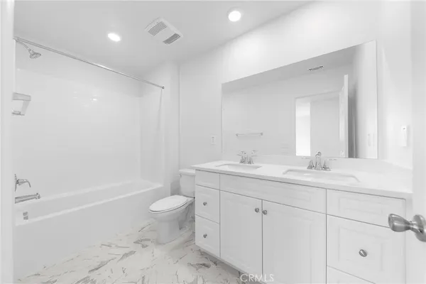a bathroom with a double vanity sink toilet and shower