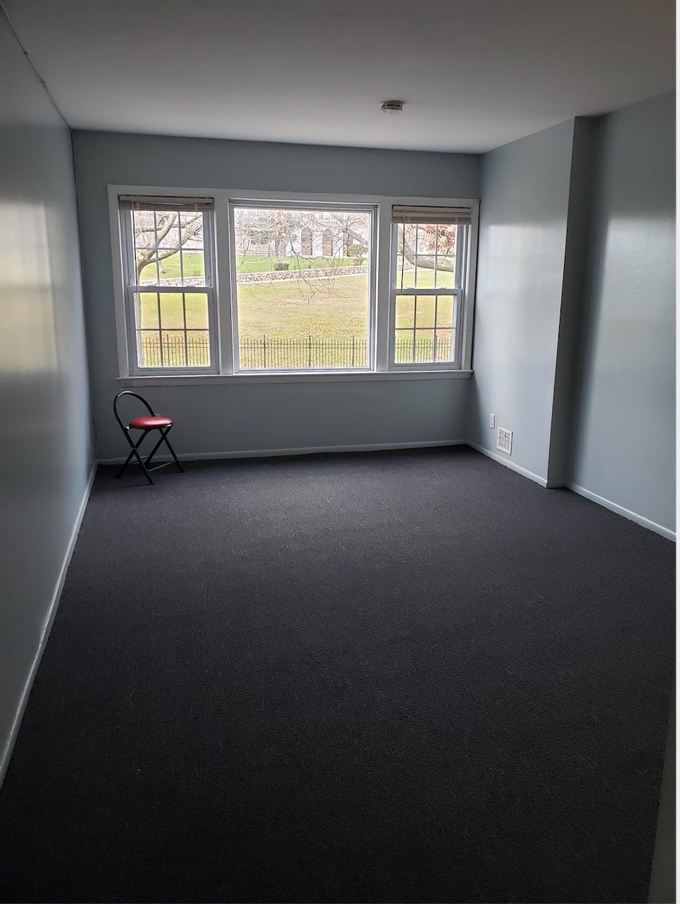 166-26 Gothic Drive, Unit 2 Queens, NY 11432 - Photo 1 of 1 Unfurnished room with baseboards, a healthy amount of sunlight, and dark colored carpet