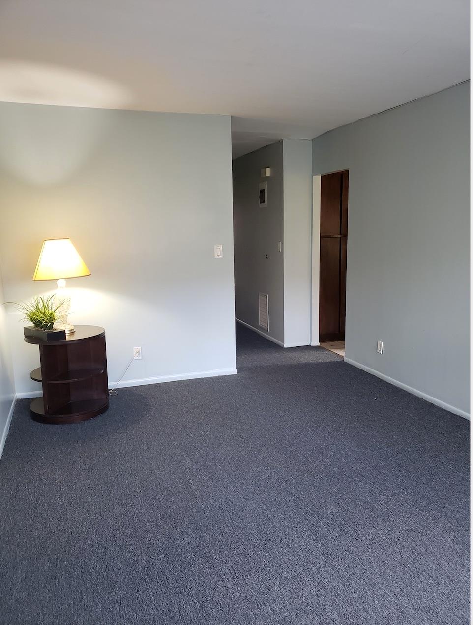 166-26 Gothic Drive, Unit 2 Queens, NY 11432 - Photo 2 of 10 Empty room with visible vents, baseboards, and dark carpet