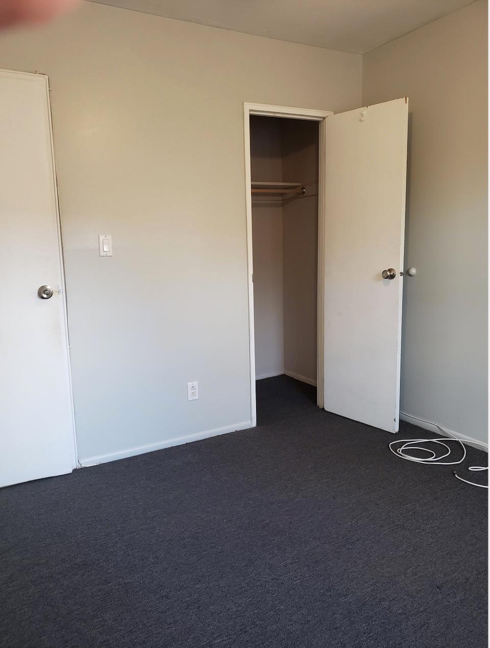 166-26 Gothic Drive, Unit 2 Queens, NY 11432 - Photo 6 of 10 Unfurnished bedroom featuring dark carpet and a closet