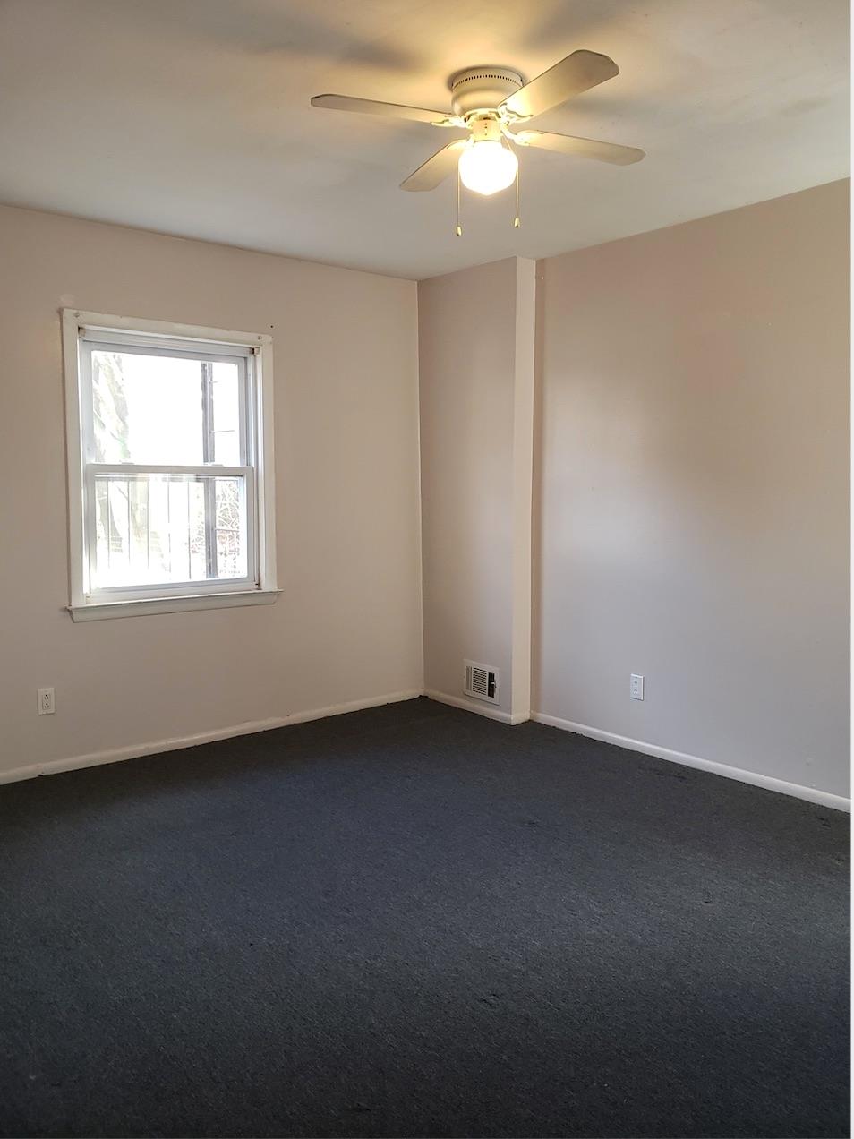166-26 Gothic Drive, Unit 2 Queens, NY 11432 - Photo 7 of 10 Spare room featuring ceiling fan, baseboards, dark colored carpet, and visible vents
