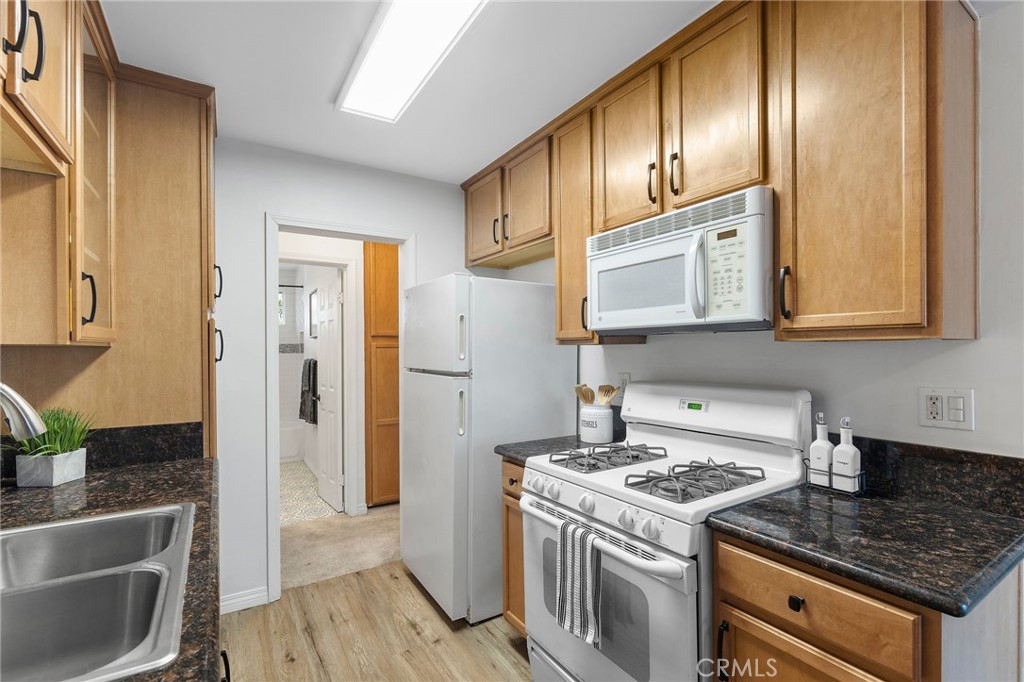 1450 West Lambert Road, Unit 358 La Habra, CA 90631 - Photo 13 of 31 a kitchen with granite countertop wooden cabinets and stainless steel appliances
