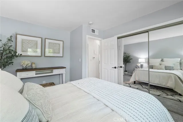 a bedroom with a bed a mirror and a lamp