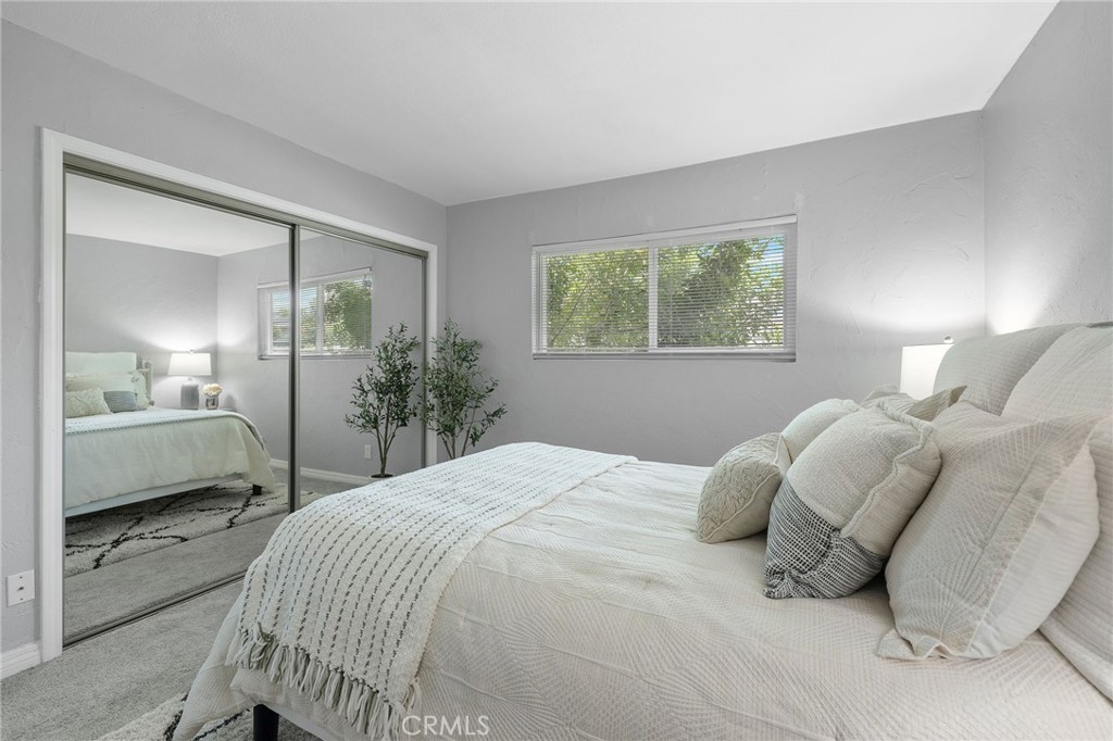 1450 West Lambert Road, Unit 358 La Habra, CA 90631 - Photo 21 of 31 a bedroom with a bed a mirror and a lamp