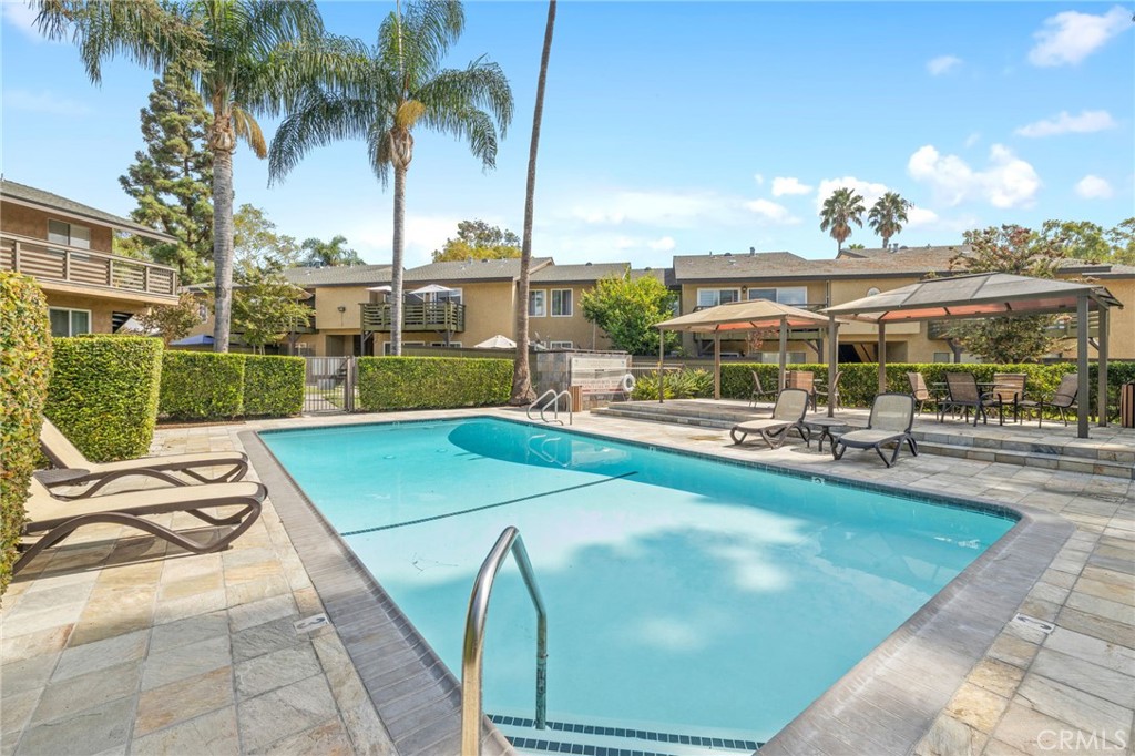 1450 West Lambert Road, Unit 358 La Habra, CA 90631 - Photo 22 of 31 a view of a swimming pool with a lounge chair and palm trees