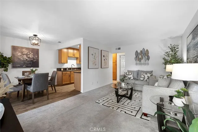 a living room with furniture and a dining table with rug kitchen