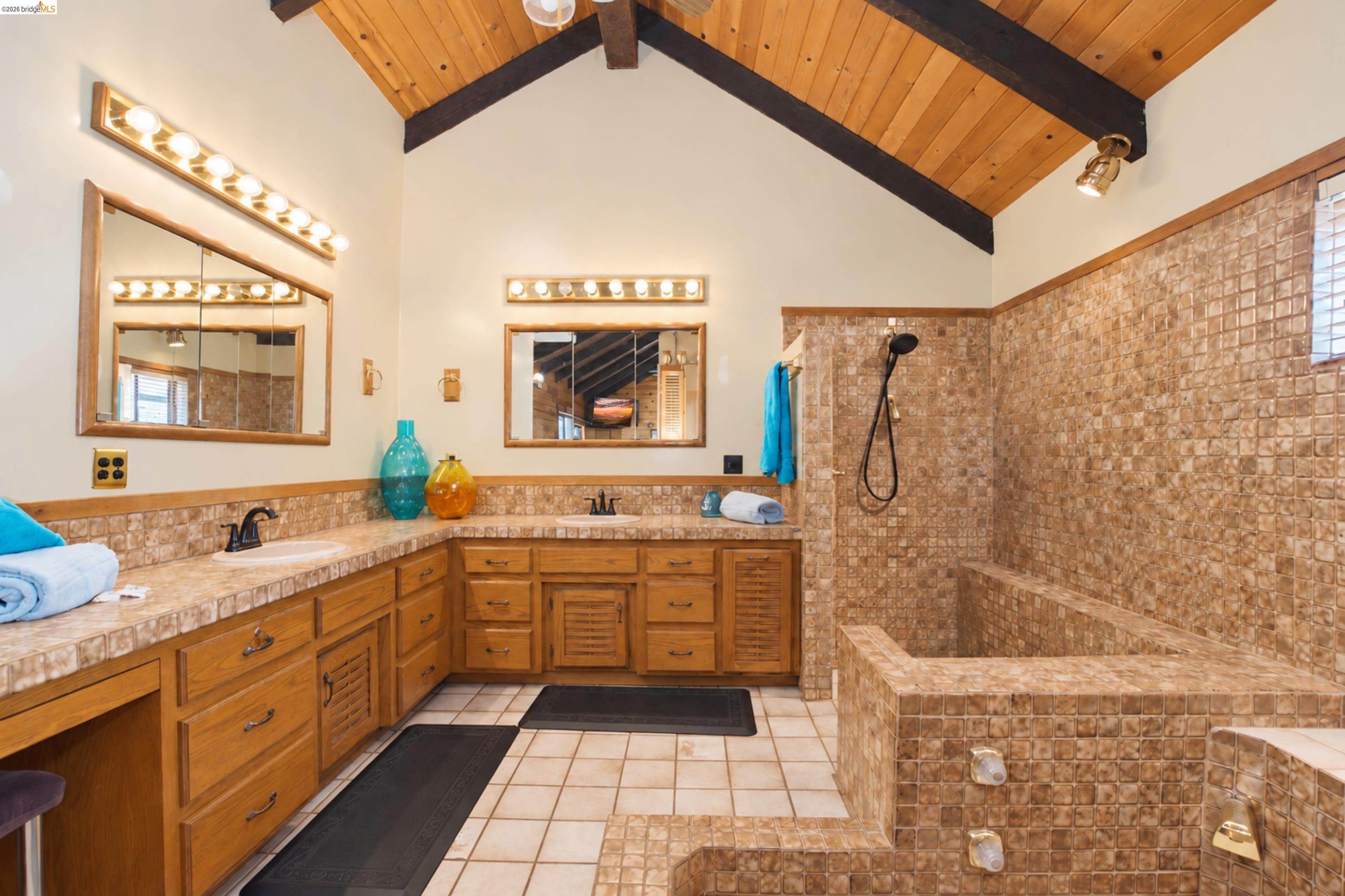 340 West Bolton Road Oakley, CA 94561 - Photo 48 of 87 Vaulted wood-paneled ceiling with exposed beams, dual vanity with laminate countertops, integrated sinks, wood cabinetry, and a tile-enclosed soaking tub