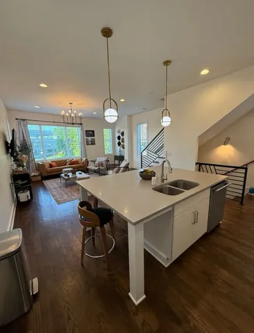 a kitchen with a table chairs sink and wooden floor
