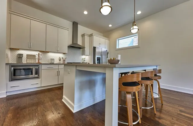 a kitchen with stainless steel appliances granite countertop a stove a sink and a microwave
