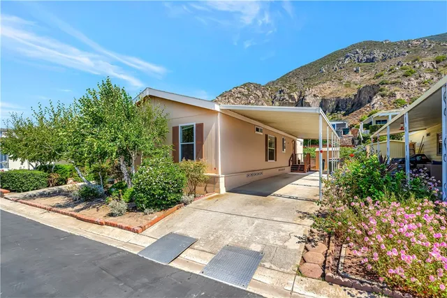 a view of a house with many windows next to a yard