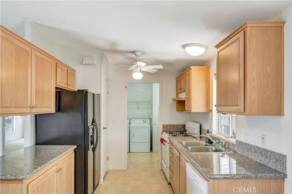 24 Gitana Avenue, Unit 164 Camarillo, CA 93012 - Photo 12 of 52 a kitchen with stainless steel appliances granite countertop a refrigerator a sink dishwasher a stove with wooden cabinets and floor