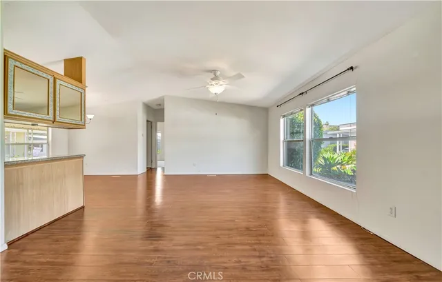 a kitchen with stainless steel appliances granite countertop a refrigerator a sink dishwasher a stove with wooden cabinets and floor