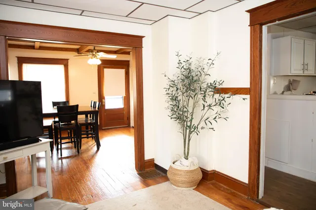 a view of a living room and a dining room with wooden floor windows