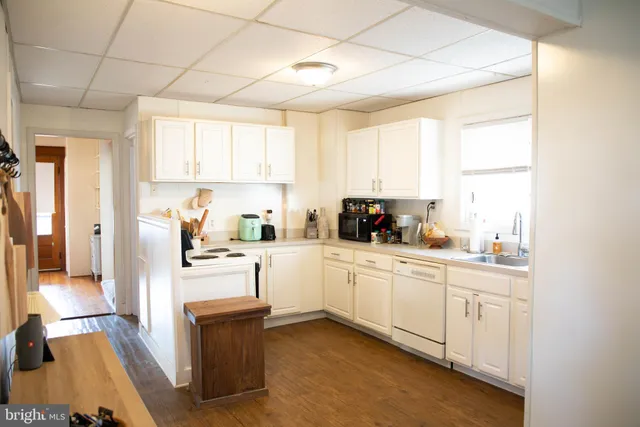 a kitchen with white cabinets and white appliances