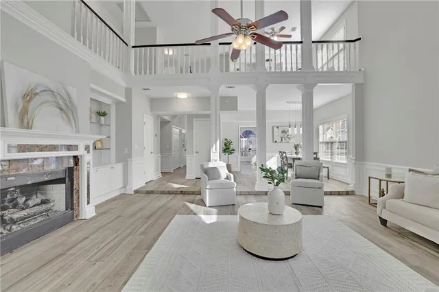 a living room with furniture a fireplace and a chandelier
