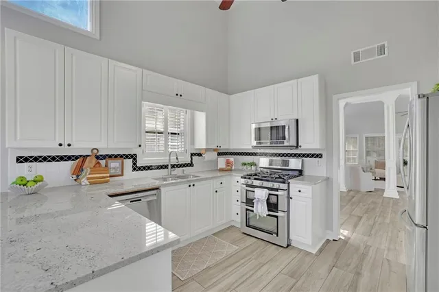 a kitchen with stainless steel appliances granite countertop a stove a sink dishwasher and a refrigerator
