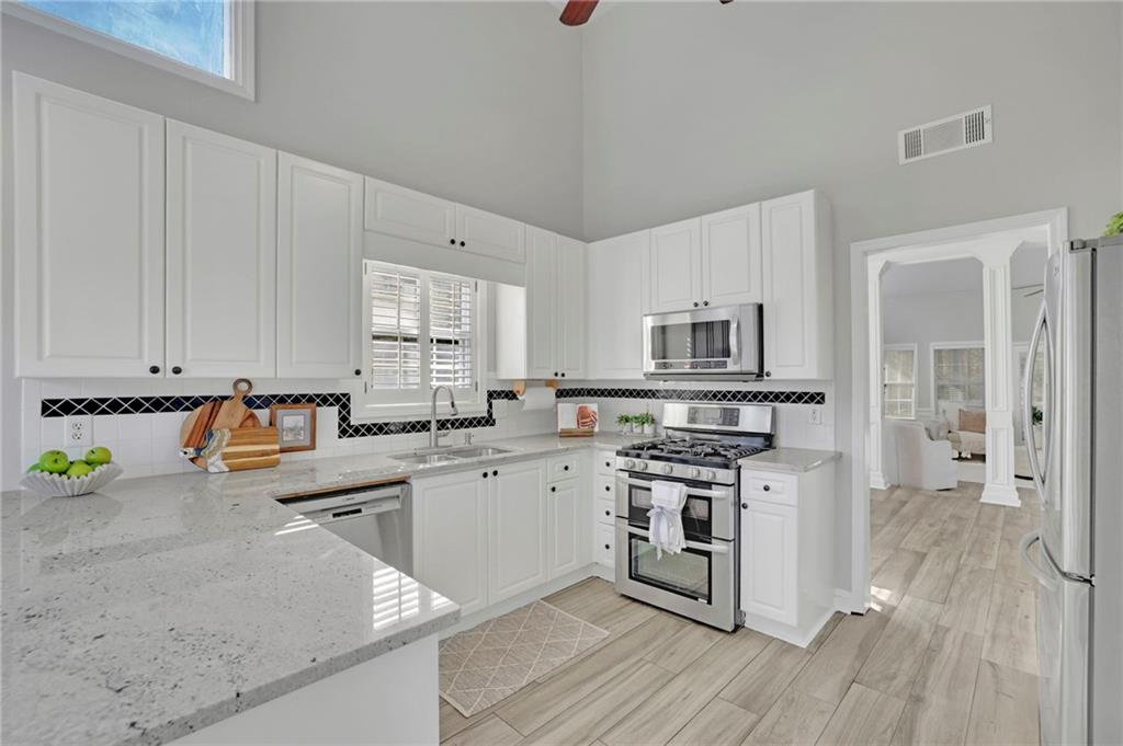 5696 Kilrush Court Mableton, GA 30126 - Photo 15 of 46 a kitchen with stainless steel appliances granite countertop a stove a sink dishwasher and a refrigerator