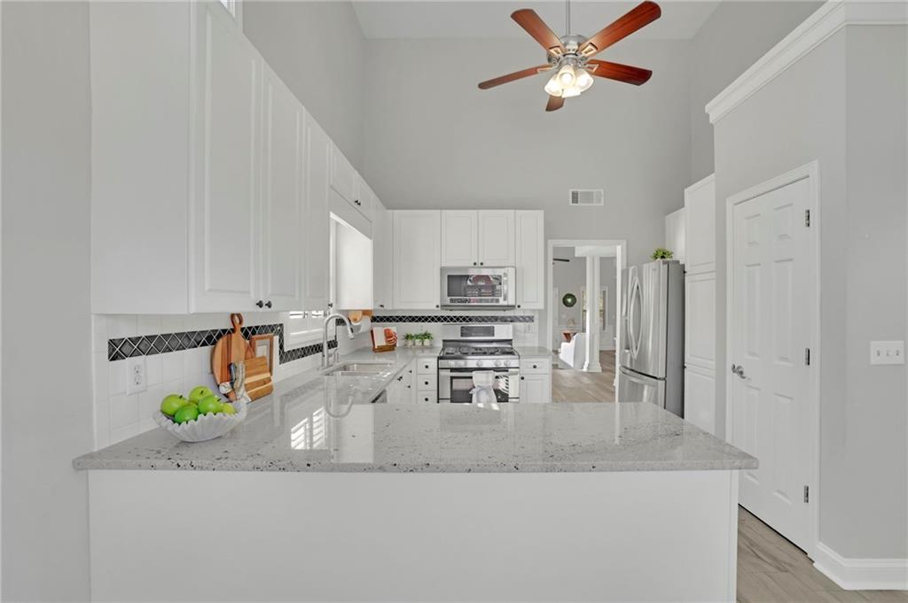 5696 Kilrush Court Mableton, GA 30126 - Photo 17 of 46 a kitchen with stainless steel appliances granite countertop a sink a stove counter space and cabinets