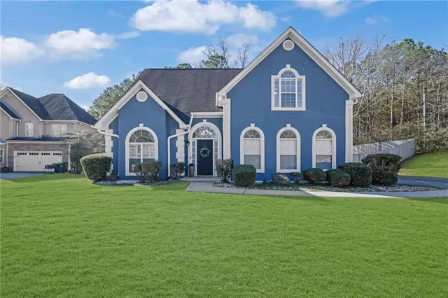 a front view of a house with garden and yard