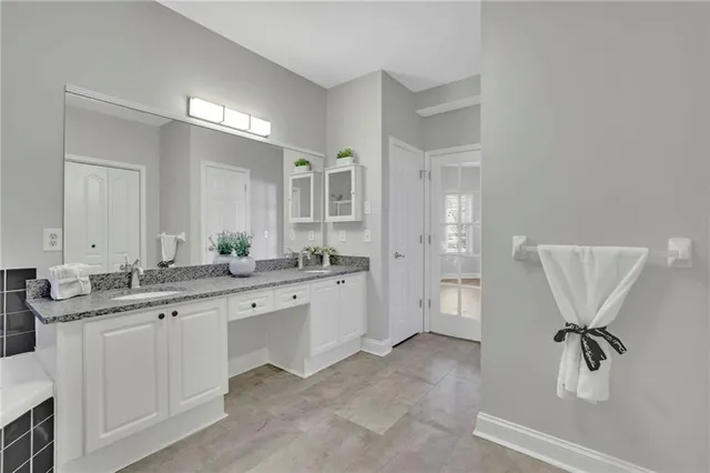 a spacious bathroom with a granite countertop sink a toilet a mirror and shower