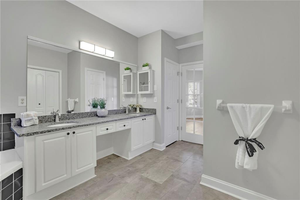 5696 Kilrush Court Mableton, GA 30126 - Photo 27 of 46 a spacious bathroom with a granite countertop sink a toilet a mirror and shower
