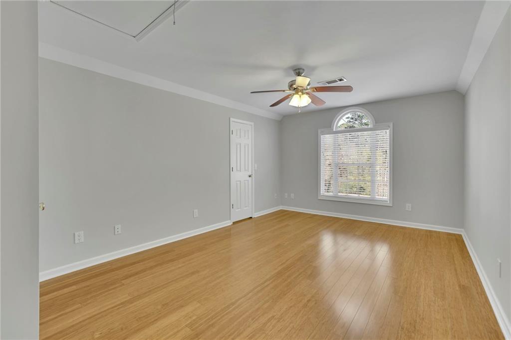 5696 Kilrush Court Mableton, GA 30126 - Photo 34 of 46 an empty room with wooden floor chandelier fan and windows