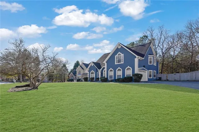 a front view of a house with a yard and trees