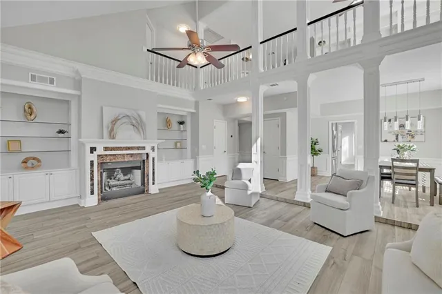 a living room with furniture a fireplace and a chandelier