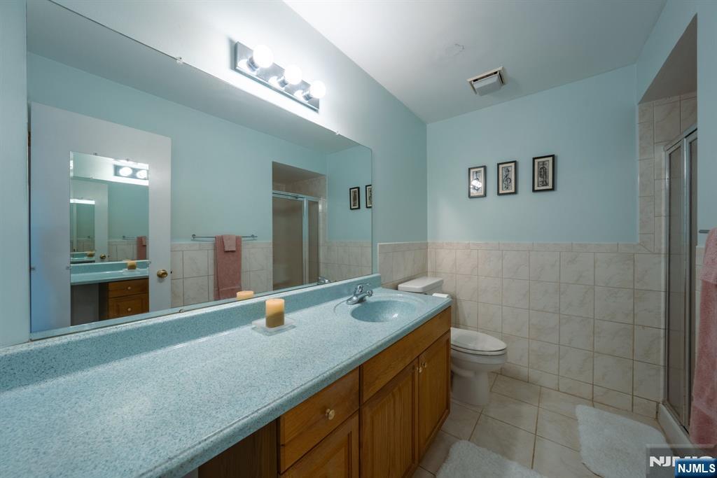 208 Federal Hill Road Pompton Lakes, NJ 07442 - Photo 18 of 22 a bathroom with a granite countertop sink a toilet and mirror
