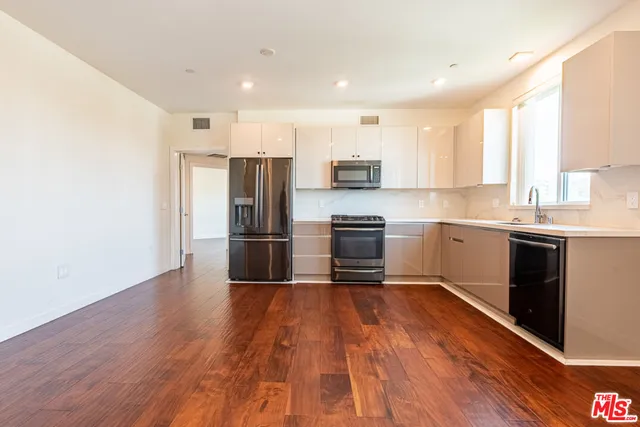 a kitchen with stainless steel appliances a refrigerator sink and cabinets
