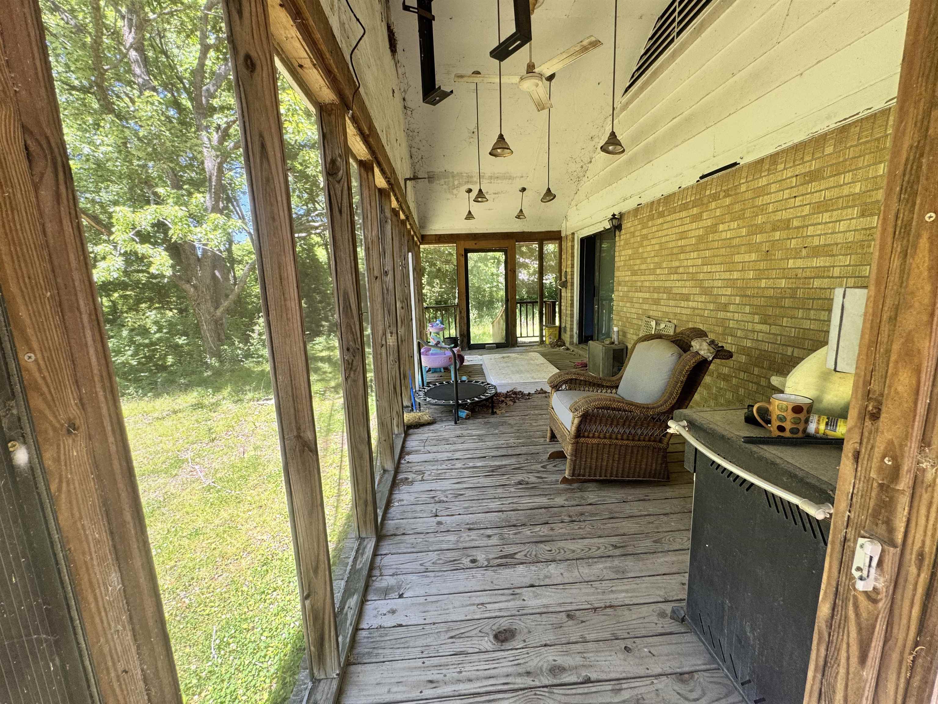 4712 Drummonds Road Drummonds, TN 38023 - Photo 31 of 38 Screened porch featuring a natural wood-finish floor, wood-framed screens, and a brick exterior wall