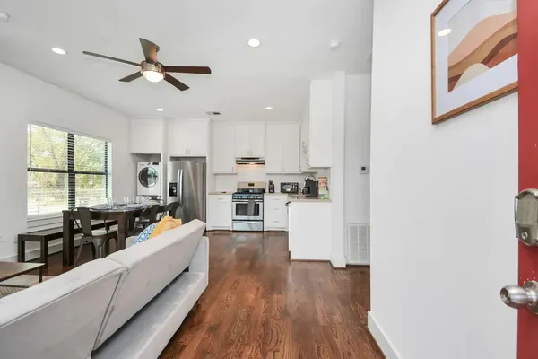 a large white kitchen with lots of counter top space and stainless steel appliances