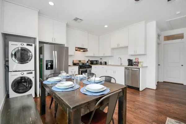a kitchen with refrigerator cabinets dining table and chairs