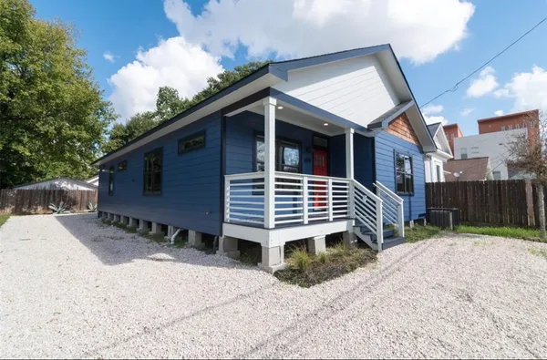 a view of a house with a yard and wooden fence