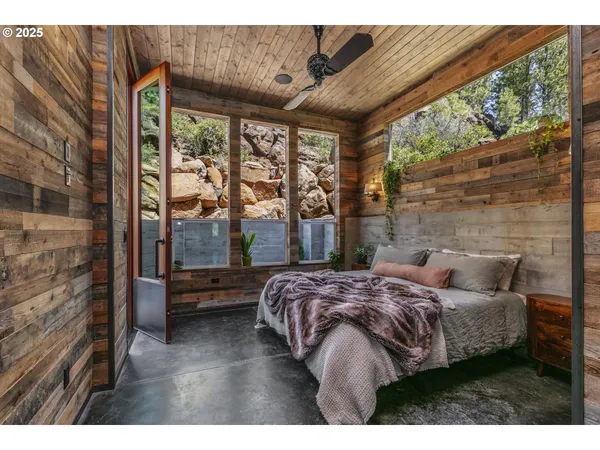 a bedroom with a bed and a large window with outer view