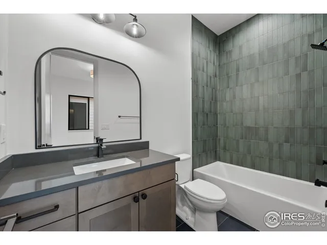 a bathroom with a toilet a sink a mirror and bathtub