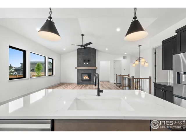 a kitchen with kitchen island a sink stainless steel appliances and a chandelier