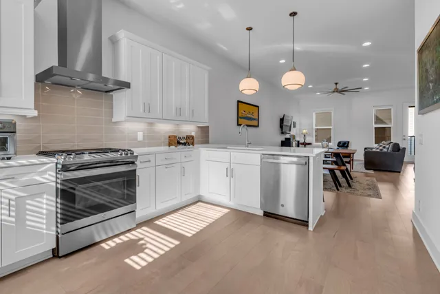 a open kitchen with a stove a sink a cabinets and a wooden floor
