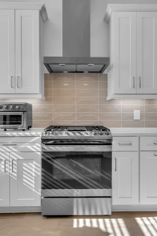 a stove top oven sitting inside of a kitchen