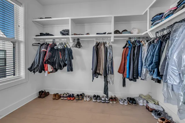 a view of walk in closet with clothes and shoes