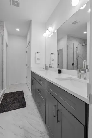 a spacious bathroom with double sink and a mirror