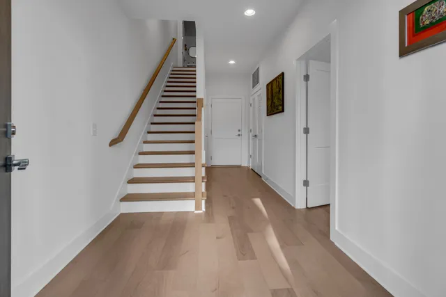 a view of a hallway with wooden floor and entryway