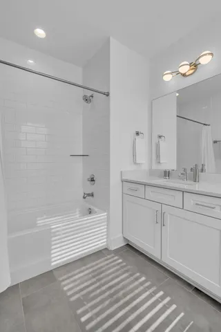 a bathroom with a sink double vanity granite tub and a shower