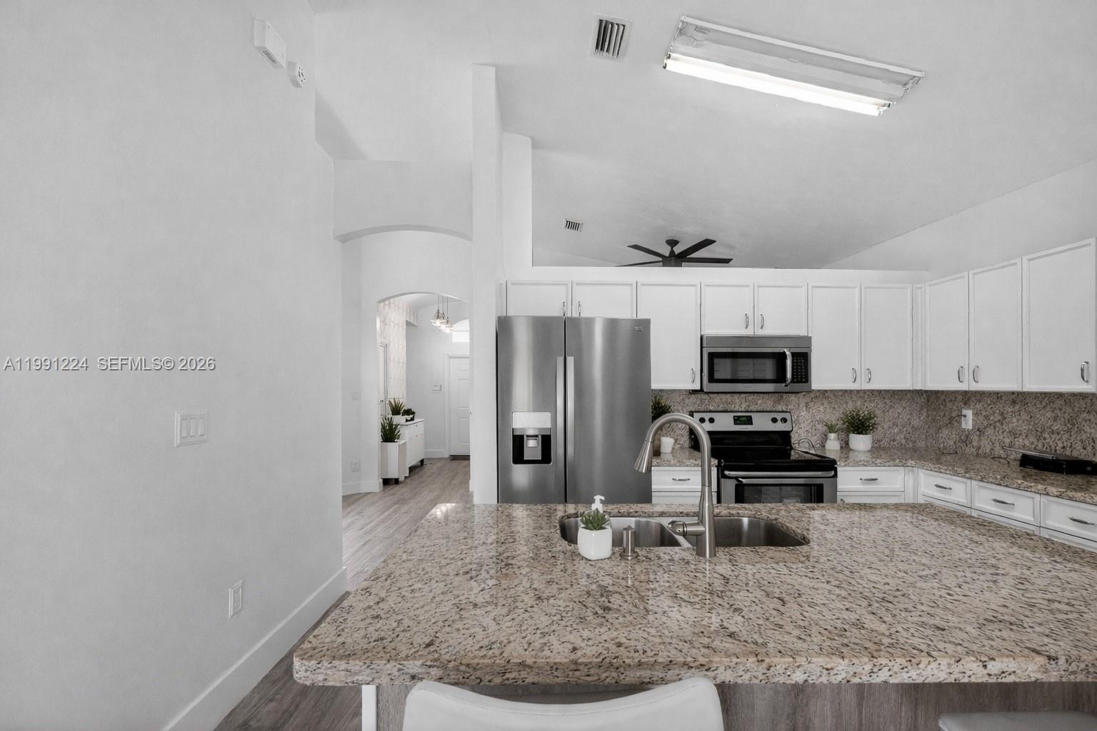 16299 Southwest 103rd Street Miami, FL 33196 - Photo 13 of 30 a kitchen with stainless steel appliances granite countertop a sink stove and refrigerator