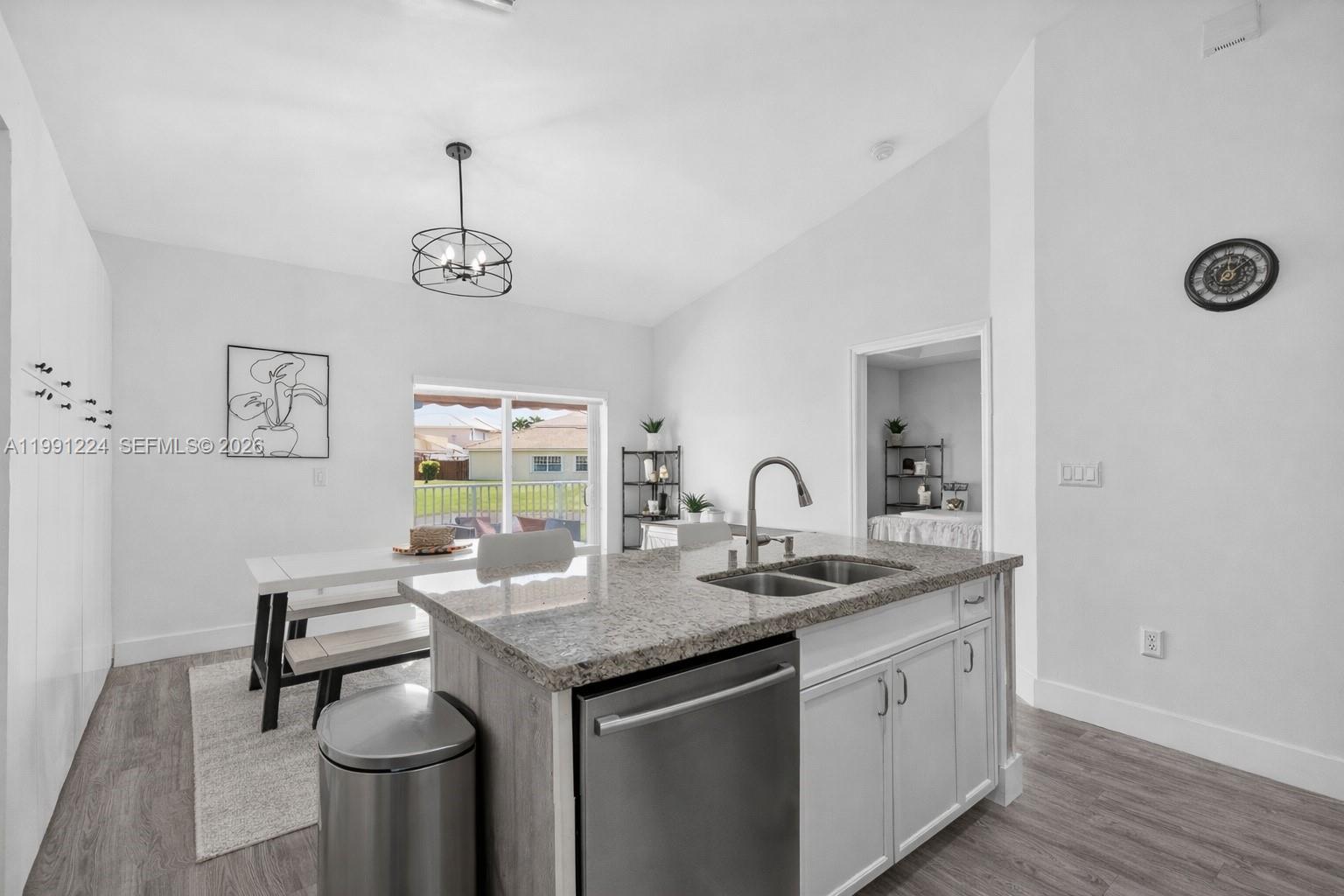 16299 Southwest 103rd Street Miami, FL 33196 - Photo 16 of 30 a kitchen with stainless steel appliances granite countertop a sink cabinets and wooden floor