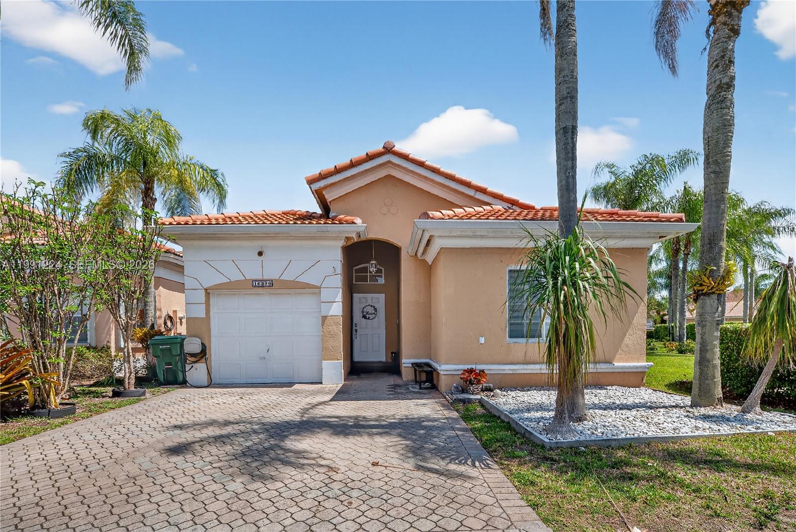 16299 Southwest 103rd Street Miami, FL 33196 - Photo 2 of 30 a front view of a house with a yard and garage