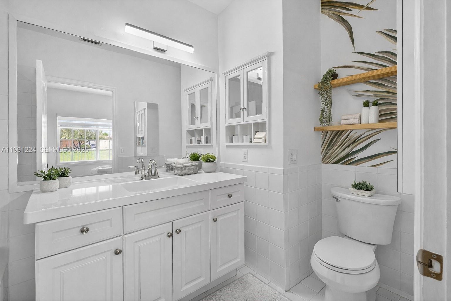 16299 Southwest 103rd Street Miami, FL 33196 - Photo 21 of 30 a bathroom with a granite countertop toilet sink and mirror