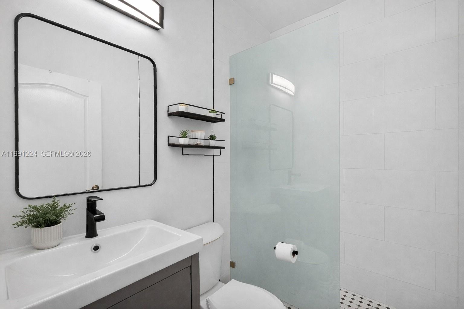 16299 Southwest 103rd Street Miami, FL 33196 - Photo 24 of 30 a bathroom with a sink a toilet and mirror