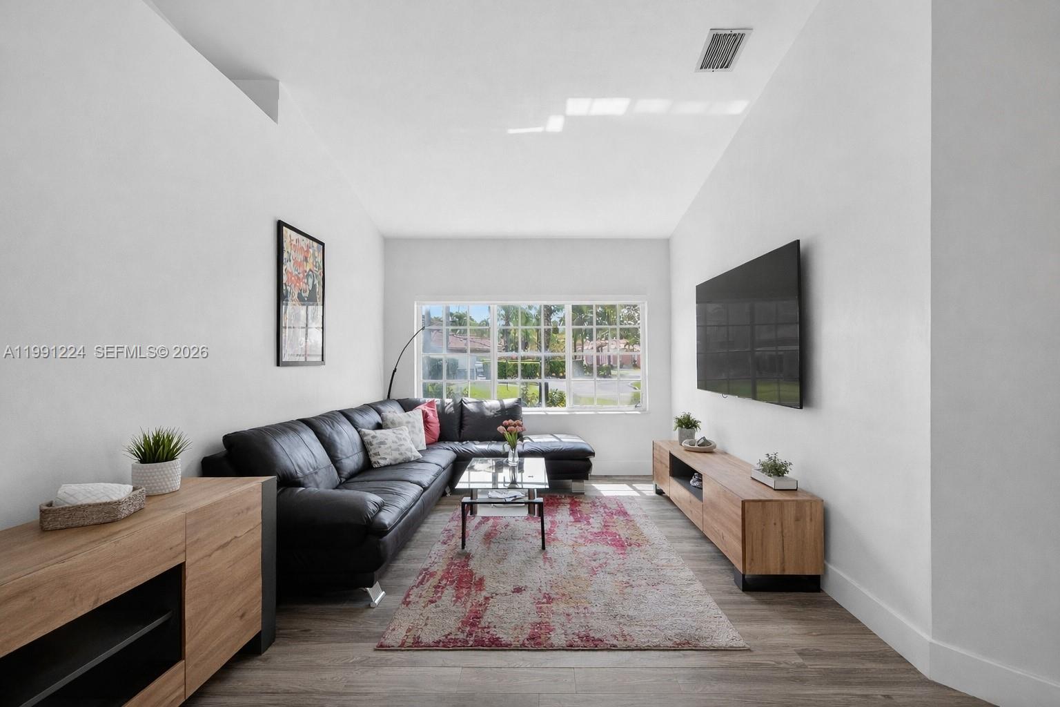 16299 Southwest 103rd Street Miami, FL 33196 - Photo 8 of 30 a living room with furniture and a flat screen tv